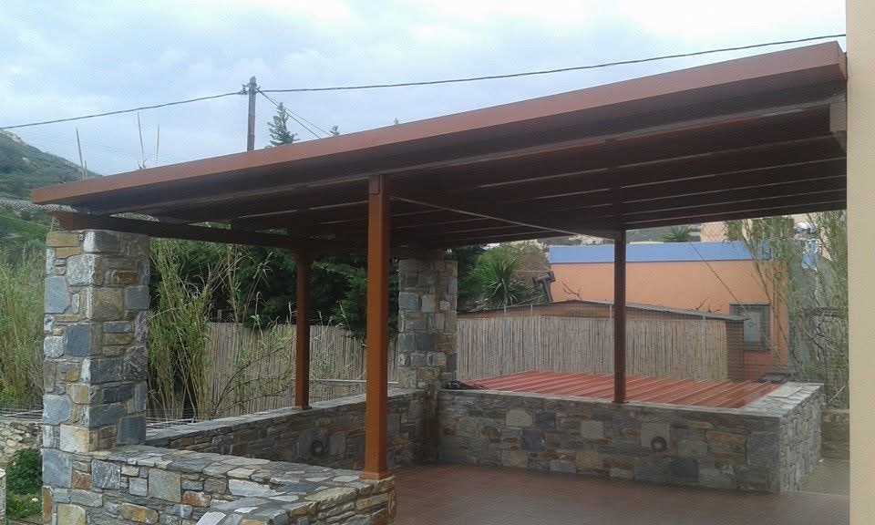 Πέργκολα σε θερμή απόχρωση δίπλα σε πέτρινα στοιχεία