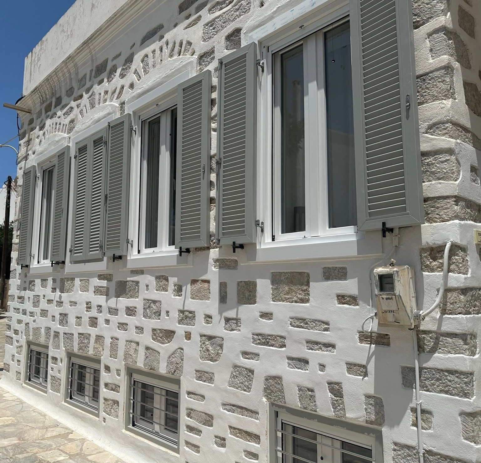 Γκρι παντζούρια σε πέτρινη κατοικία